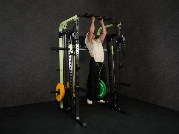 Gym Plus Power Dip Belt POWERBELT a man performing pull up using the dip belt with green bumper plates