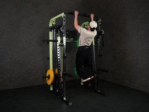 Gym Plus Power Dip Belt POWERBELT a man performing pull up using the dip belt with green bumper plates, back view