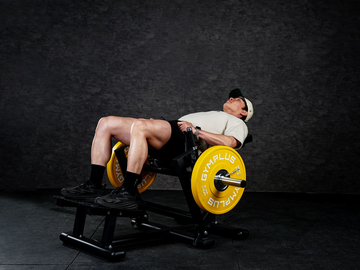Gym Plus Hip Thrust Machine - Plate Loaded BELT-HT-01 a man performing hip thrust with yellow bumper plates