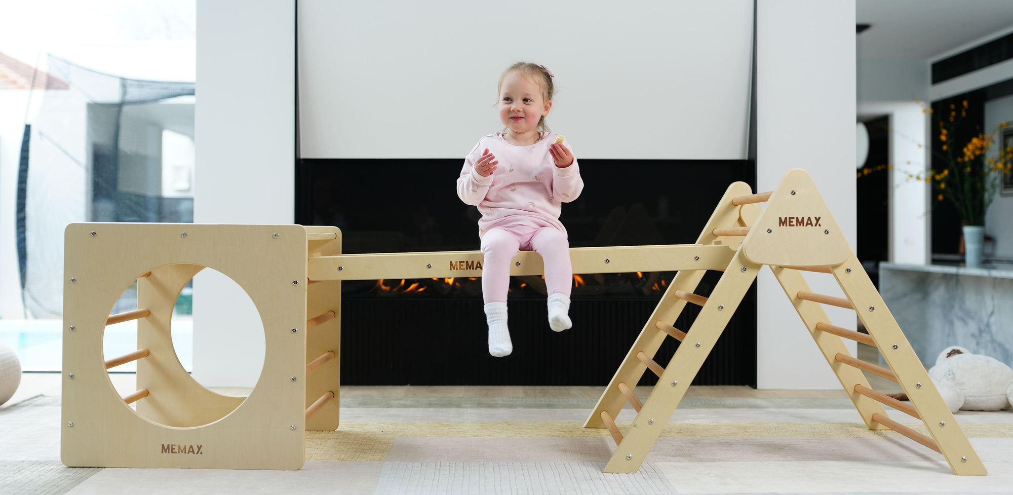 A toddler sitting on the Pikler Jungle Climbing Play Set
