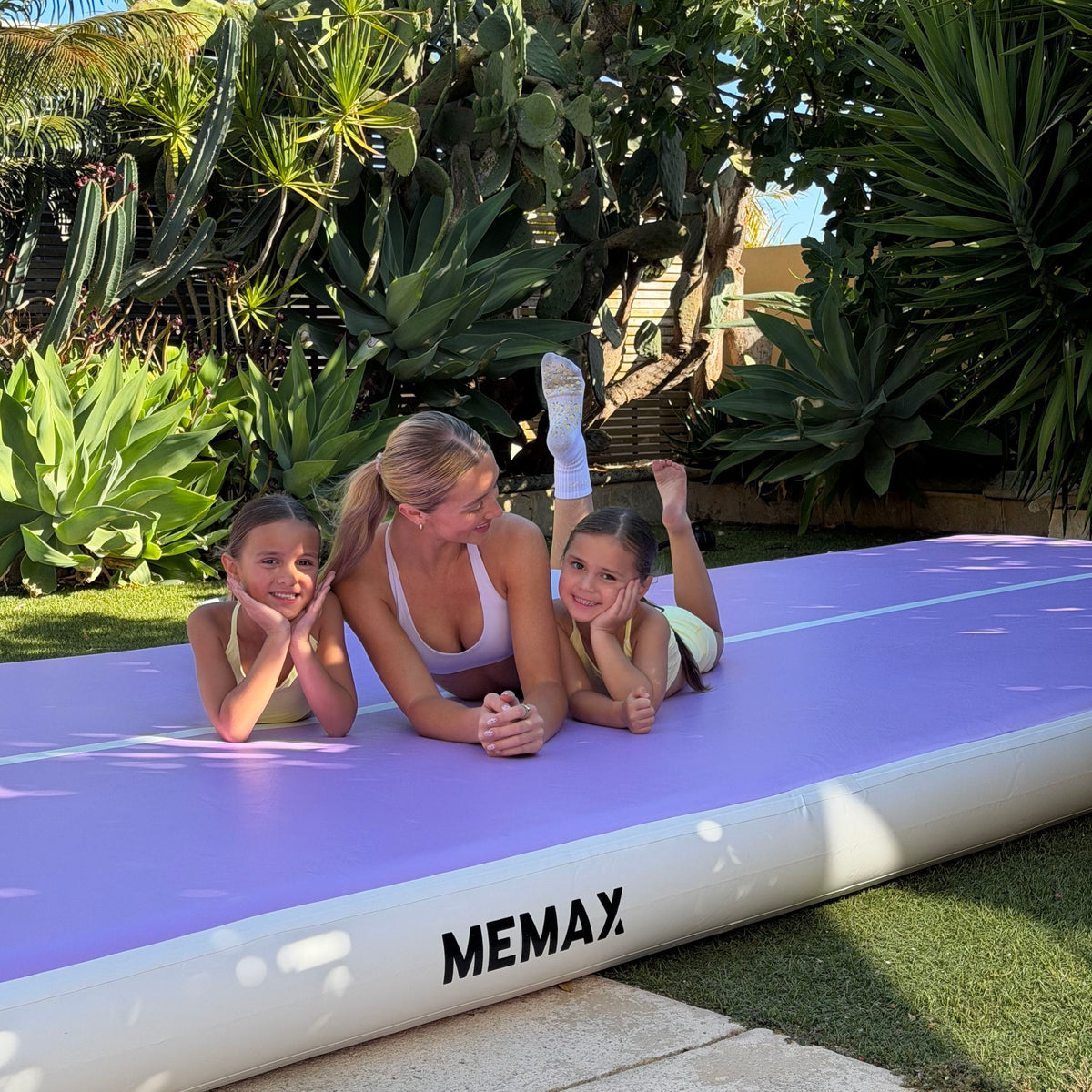 A mum and her daughters on the MEMAX Inflatable Gymnastics Air Track Mat in purple
