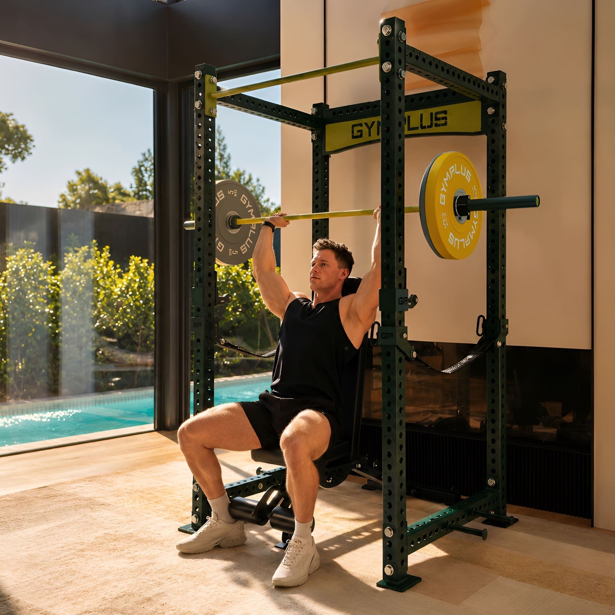 Man lifting weights in a home gym with a pool view