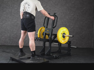 Gym Plus Belt Squat Machine - Plate Loaded BELT-SQUAT-01 a man performing belt squat with yellow bumper plates