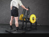 Gym Plus Belt Squat Machine - Plate Loaded BELT-SQUAT-01 a man performing belt squat with yellow bumper plates